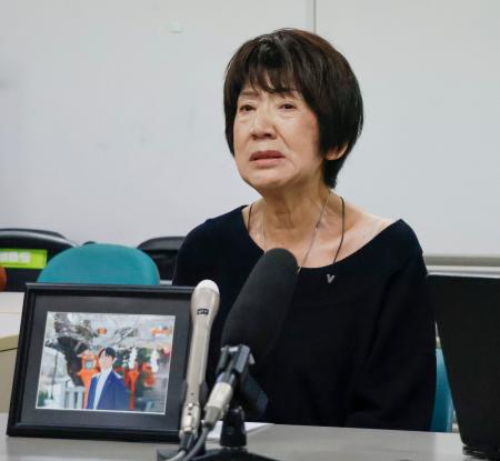 提訴後、遺影を前に記者会見する男性の母親＝１５日午後、京都市