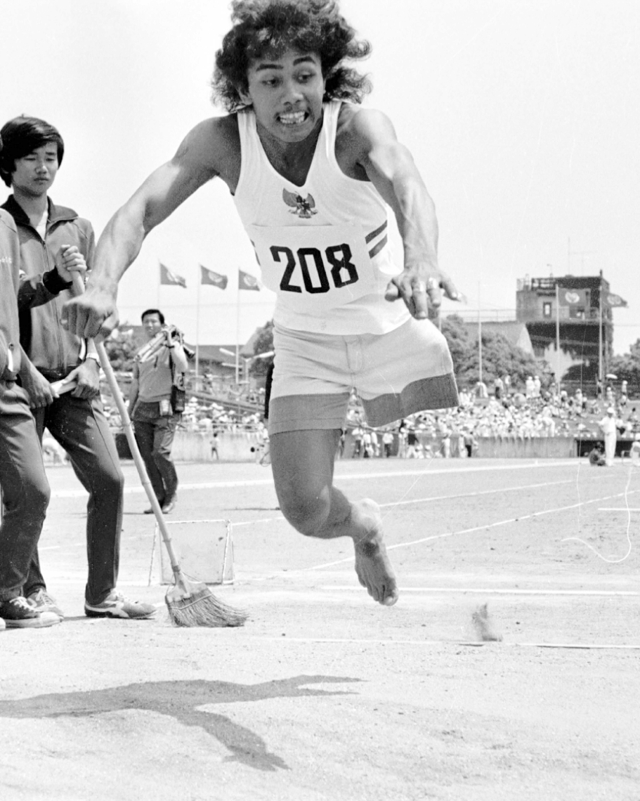 １９７５年に開かれた第１回フェスピック大会の一場面。片足でジャンプする外国人選手＝大分市営陸上競技場