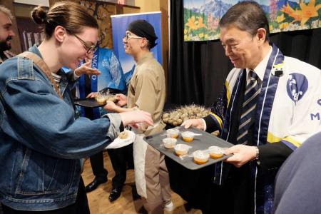 「日本ふるさと名産食品展ｉｎＮＹ」で、カレーを振る舞う宮城県の村井嘉浩知事（右）＝２４日、米ニューヨーク・ブルックリン（共同）