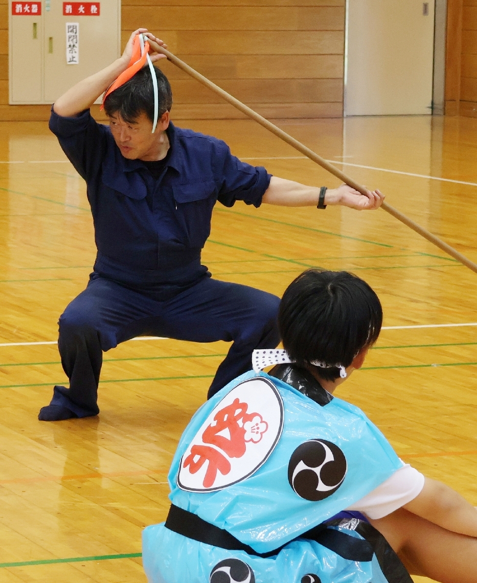 生徒に踊りの姿勢を伝える泥谷正太さん（奥）