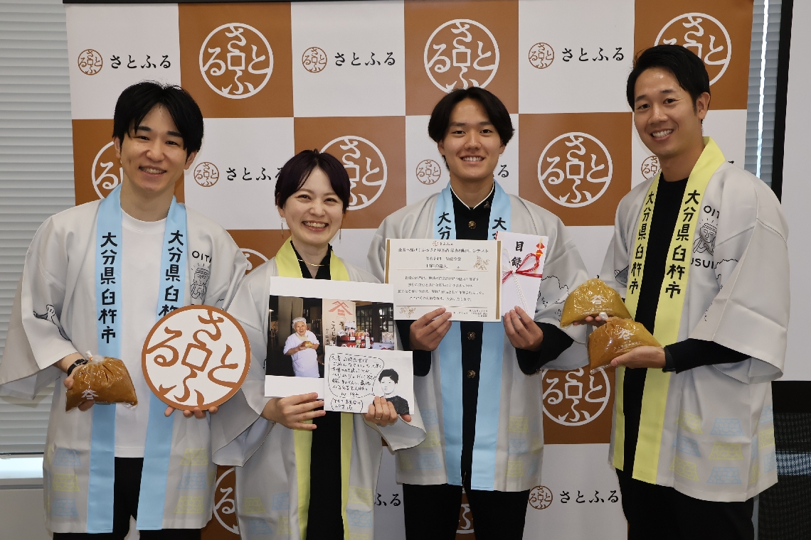 さとふるの写真・動画コンテストで最優秀賞に輝いた太田康介さん（右から２人目）や臼杵市、カニ醬油の関係者ら