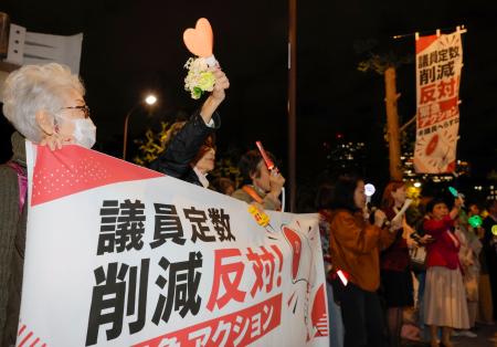 国会議員会館前で開かれた抗議集会で、衆院議員定数削減法案に反対する人たち＝２８日夜