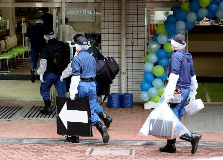 都立六本木高校に入る警察官＝３０日午後２時３９分、東京都港区